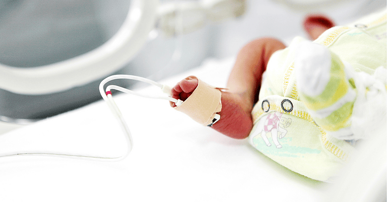 Premature baby’s foot with a hospital monitoring sensor attached in the NICU
